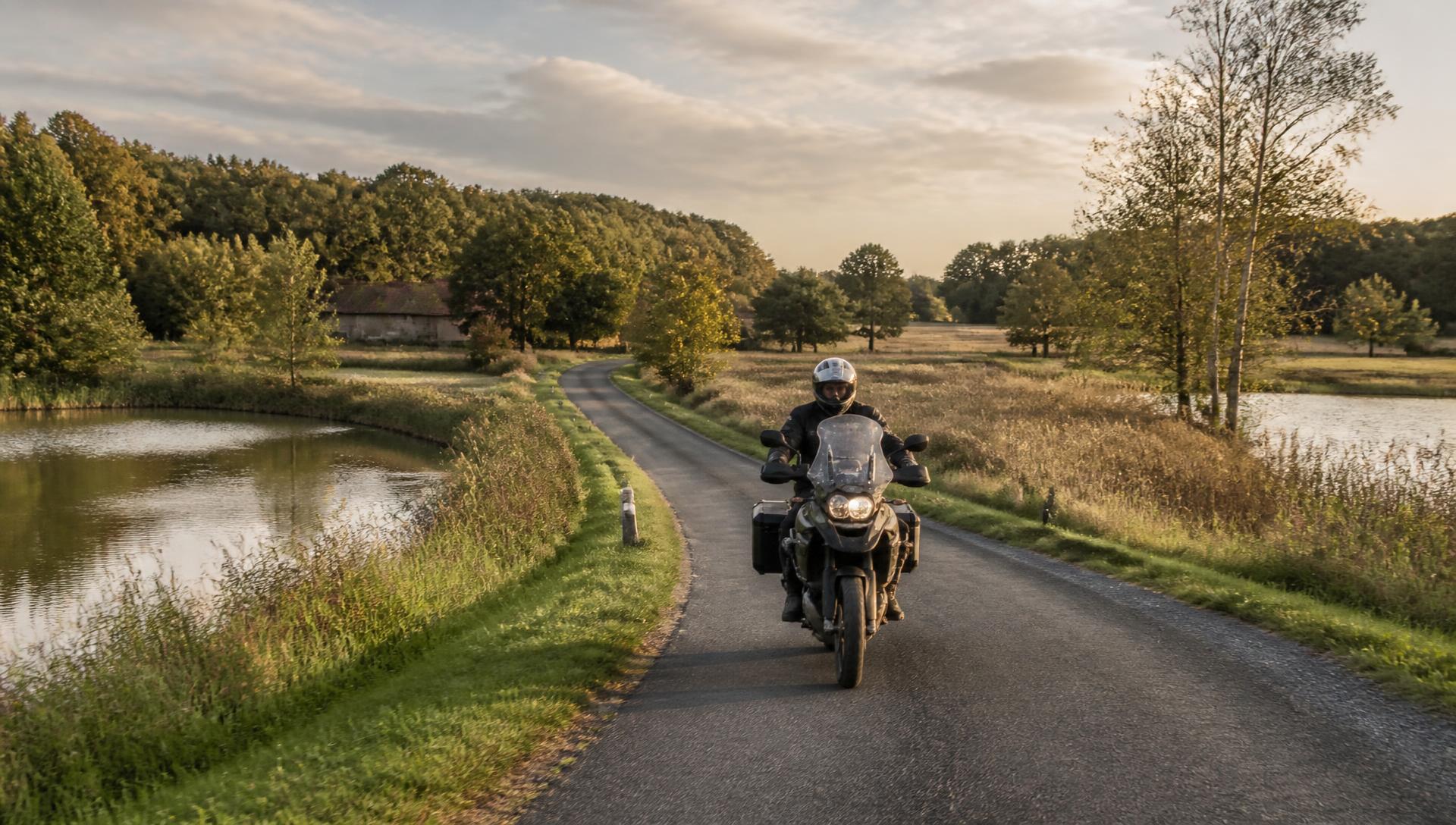 Motard sur une route de campagne entre étangs et forêts de la Brenne, dans l'Indre